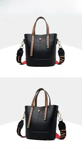 Close-up of black leather bucket bag featuring a brown handle and LOVE lettered strap