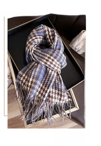 Detail of blue and brown houndstooth scarf with tassels on a luxury display tray