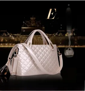 Detail of quilted champagne handbag with metal hardware and mini bottle charm