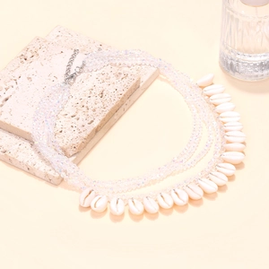 Detail of layered crystal bead necklace with white cowrie shell pendants and silver clasp