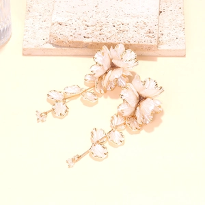 Detail of handmade beaded flower drop earrings with gold edges and long tassel fringe