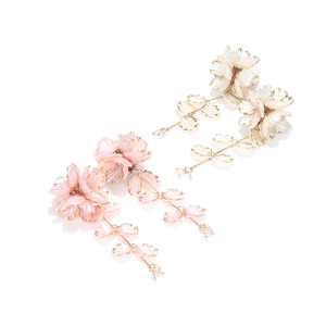 Detailed close-up of handmade beaded floral earrings with gold-edged fringe leaves