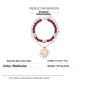 Detail of bohemian layered necklace featuring red resin beads and golden sun pendant