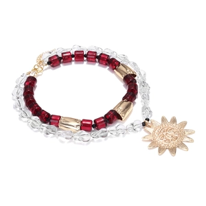 Bohemian multilayer beaded necklace with a gold sun pendant and red resin accents