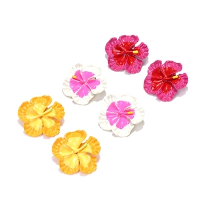 Detailed macro of tropical frangipani earrings in three gradient enamel flower colors