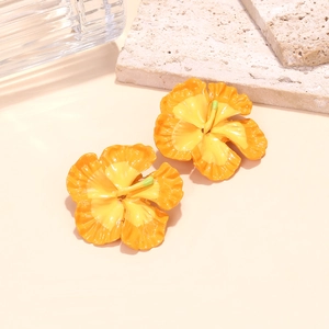 Detailed macro view of orange gradient frangipani earrings with glossy enamel texture