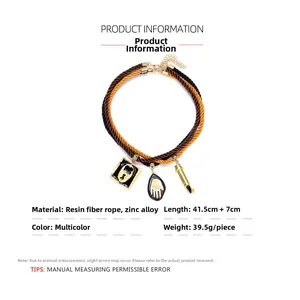 Detail of bohemian layered rope necklace featuring enamel lock and hand pendants
