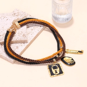 Detail of layered rope necklaces with gold pendants and adjustable extension chain