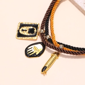 Detailed close-up of multilayered rope chain with vintage oil-drop pendants and palm relief