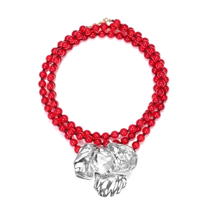 Three-layer beaded necklace with vibrant red beads and large silver abstract floral pendant