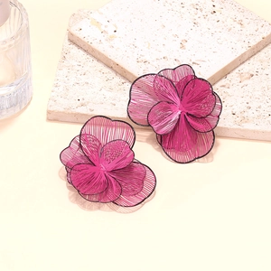 Detail view of 3D layered magenta metal mesh flower earrings with black trim
