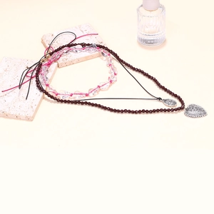 Detail view of double-layer vintage necklace with heart pendant on stone display
