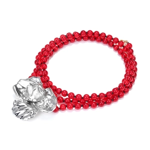 Three-layer red beaded necklace featuring a large metallic floral pendant on white background