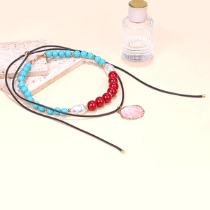 Detailed shot of beaded summer necklace with turquoise, pearls and pink shell pendant