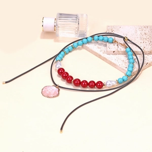 Layered beaded necklace featuring turquoise beads, pearls and a pink shell pendant