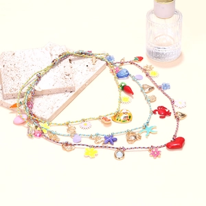 Detailed view of layered woven ropes with colorful enamel heart and starfish pendants