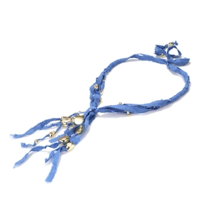 Close-up of handmade blue textile necklace with gold geometric pendants in boho style