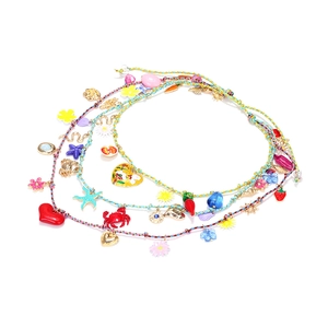 Detail of layered woven ropes with heart, starfish, and colorful enamel charms necklaces