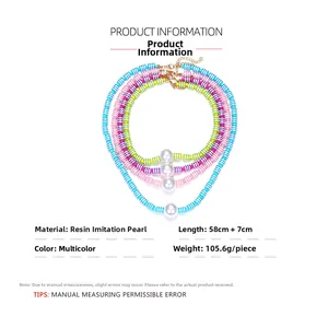 Détail de colliers en perles de résine multicouches avec perles blanches et fermoirs dorés
