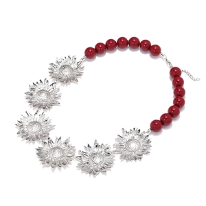 Détails des pendentifs tournesol argentés et du collier de perles rouges avec fermoir