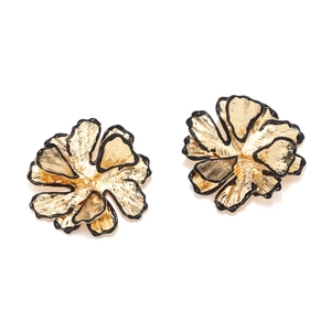 Detail of gold metal flower earrings with black oil drip edges and brushed petal texture