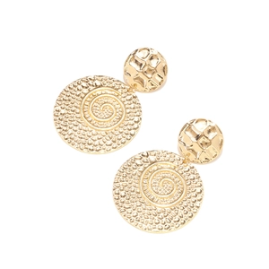 Macro view of gold spiral texture and hammered finish on vintage geometric earrings