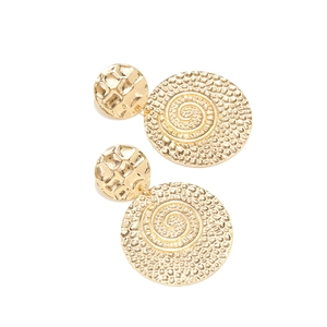 Macro shot of gold vintage circular earrings with spiral texture and hammered finish