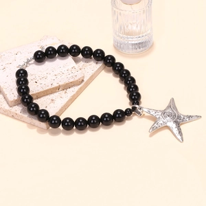 Detailed close-up of a black beaded necklace featuring a large vintage silver starfish pendant