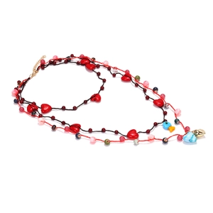 Collier multi-rangs avec perles cœurs rouges, pendentif poisson et fermoir doré sur blanc
