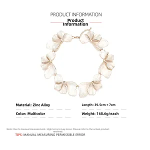 Detailed macro of white enamel petal necklace with gold-toned edges and zinc alloy chain
