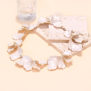 Detailed close-up of enamel petal necklace with gold edges on stone background