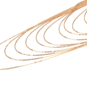 Detailed macro view of tiered gold disk link chains with polished minimalist finish