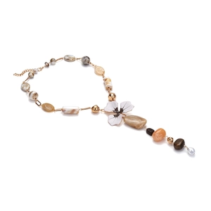 Collier artisanal perlé avec un pendentif fleur en résine blanche et détails de perles