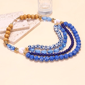Dettaglio di collana bohémien a strati con perline blu sfumate e chiusura a moschettone