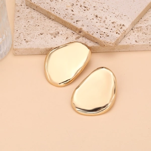 Detailed view of irregular pebble-shaped gold earrings with a high-polished mirror finish