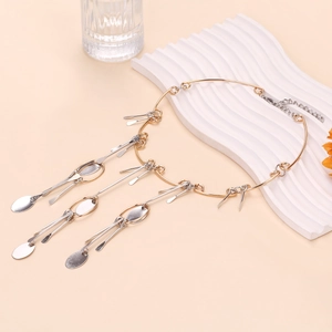 Détail d'un collier à franges multicouches avec pendentifs argent sur cadre doré