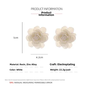 Détail de la boucle d'oreille fleur en résine blanche avec centre perlé et dimensions