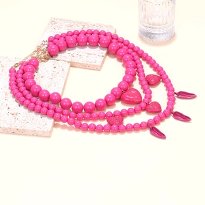 Détail du collier à perles roses multicouches avec pendentifs en cœur et fermoir homard