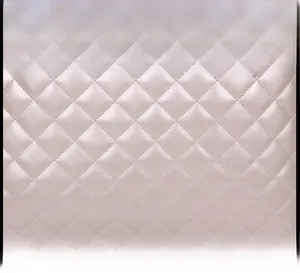Macro detail of diamond quilted faux leather with pearlescent finish and soft sheen