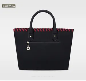 Back view of black tote bag with red braided trim and gold ring zipper pocket detail