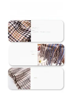 Detailed view of soft cashmere feel scarf with houndstooth pattern and fringe tassels