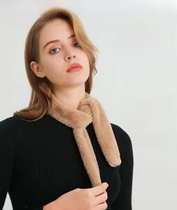 Detail of soft faux fur camel scarf with plush texture paired with black knit sweater