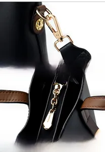 Close-up of golden metal hooks and hardware details on a black leather handbag
