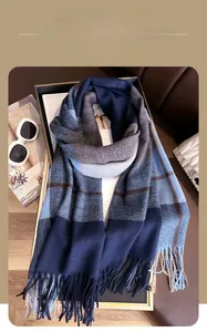 Detail of winter thick plaid scarf with tassels, sunglasses, and magazine flat lay