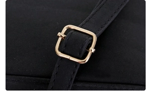 Detailed macro view of black suede strap featuring a polished gold square buckle