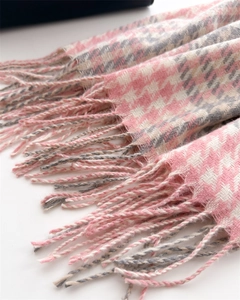 Close-up of pink and grey houndstooth scarf with hand-twisted tassel details