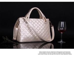 Detail of beige quilted leather handbag featuring elegant gold hardware and shoulder strap