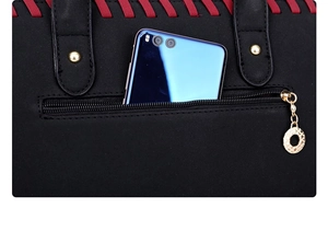 Close-up of black leather handbag back view featuring a zipper pocket and golden hardware