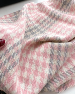 Macro shot of pink and grey hounds-tooth cashmere scarf showing fabric texture and tassels