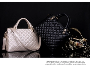 Close-up of quilted pattern and gold handle on beige and black handbags